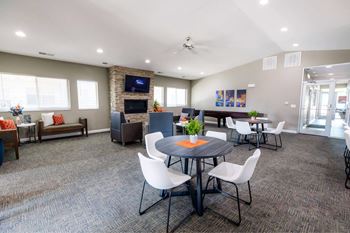 A conference room with a table, chairs, and a television on the wall.